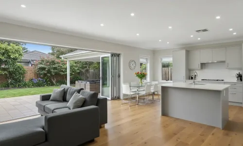 Modern open-plan living area with seamless kitchen, dining, and lounge space in Sydney renovation.
