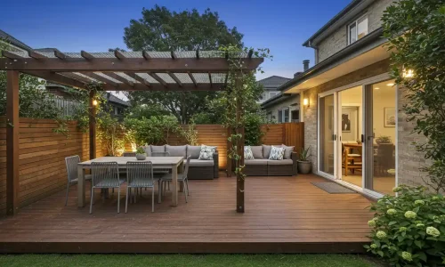 Stylish outdoor deck with dining area, seating, and greenery.